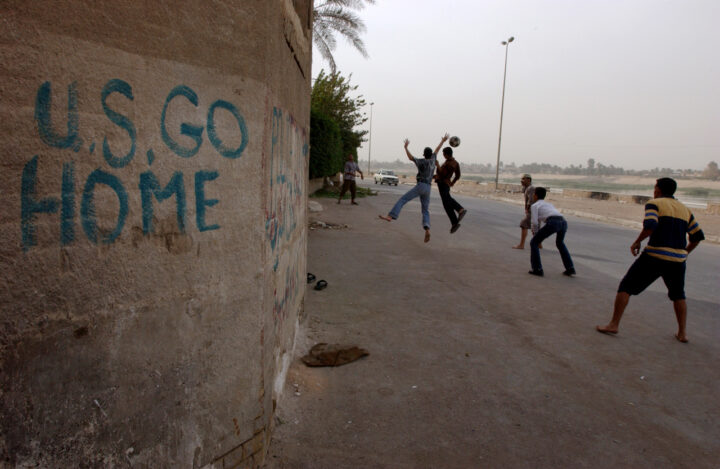 Here, a soccer team trains its goalie against a building's wall inscribed with carefully painted anti-American grafitti, in English reading: "U.S. GO HOME"