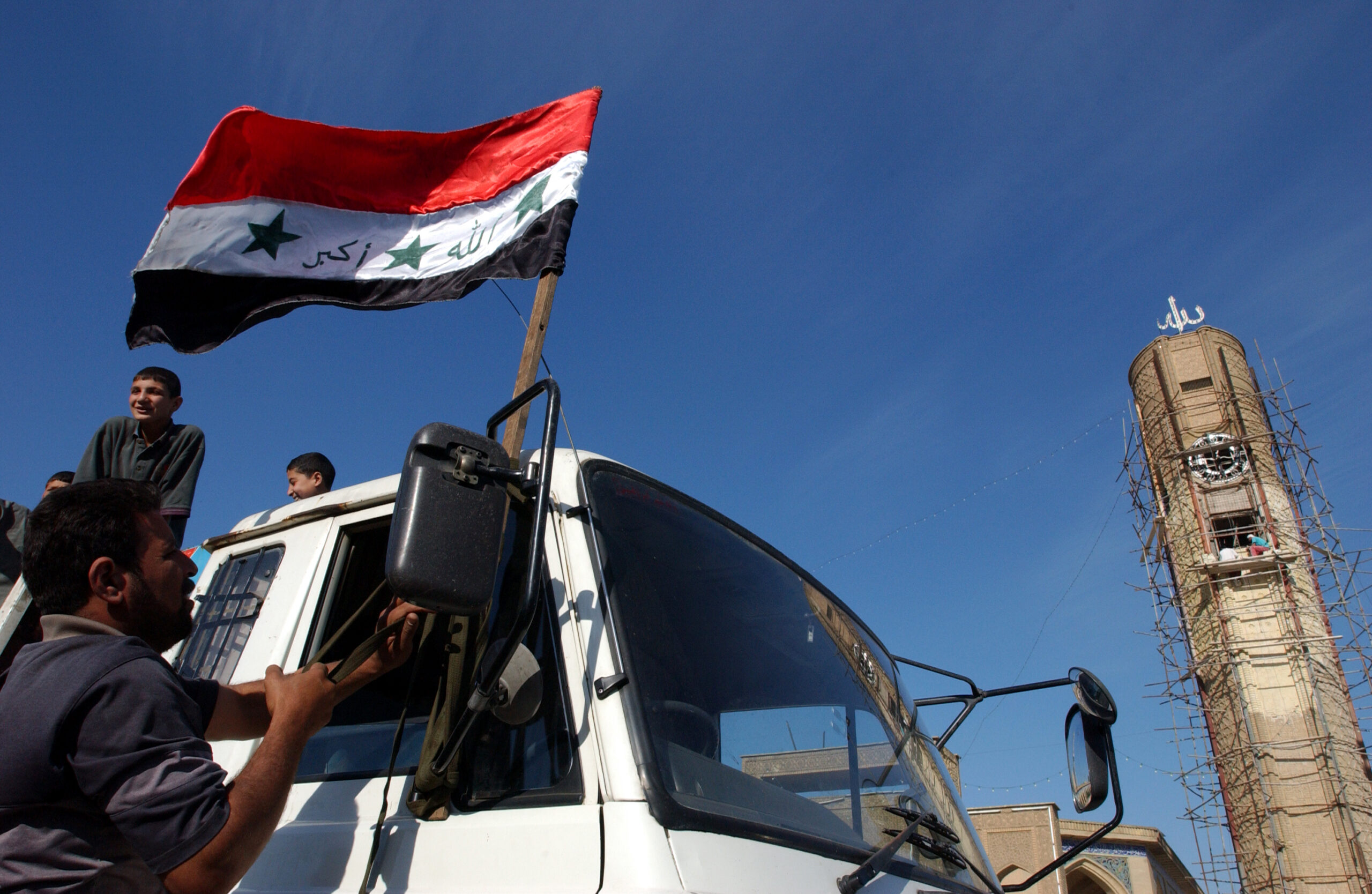 A truckdriver ties an Iraqi flag to his truck in preparation to take relief supplies that have been collected from all over Baghdad.