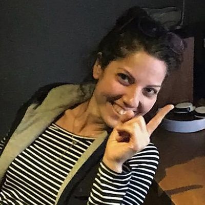 Luciana Fernandes Luciana Fernandes laughing and pointing at something off frame.